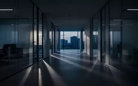 Ein minimalistischer Büroflur mit langen Schatten bei Dämmerung, der eine Atmosphäre von Anonymität und Gefahr vermittelt. - Foto: über boerse-global.de