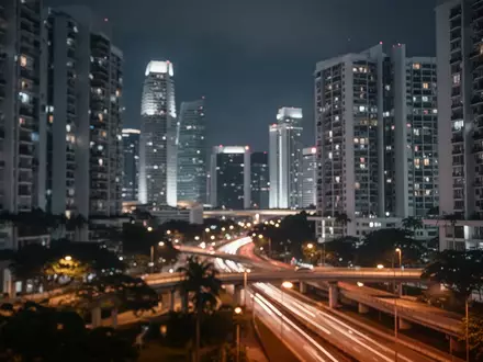 Nächtliche Skyline von Singapur mit verschwommenen Lichtern von Hochhäusern und städtischer Infrastruktur. - Foto: über boerse-global.de