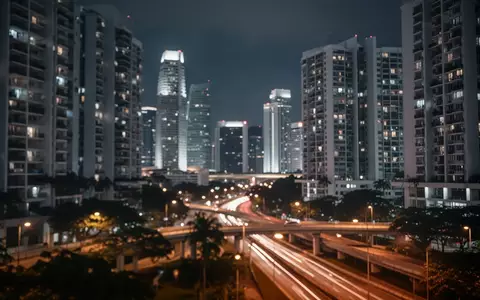 Nächtliche Skyline von Singapur mit verschwommenen Lichtern von Hochhäusern und städtischer Infrastruktur. - Foto: über boerse-global.de