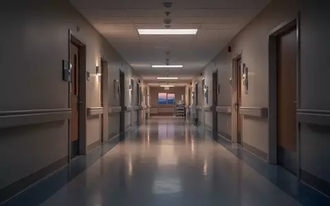 Ein leerer, ruhig beleuchteter Krankenhausflur mit glänzendem Boden in einer sterilen, architektonischen Umgebung. - Foto: über boerse-global.de