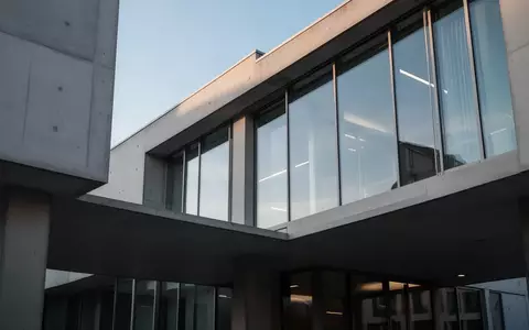 Moderne Fassade eines Finanzamtsgebäudes mit klaren Linien und Glasfronten bei Tageslicht. - Foto: über boerse-global.de