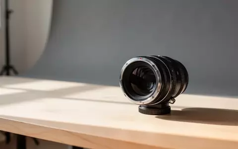 Ein hochwertiges Kameraobjektiv auf einem minimalistischen Holztisch in einem hellen Fotostudio. - Foto: über boerse-global.de