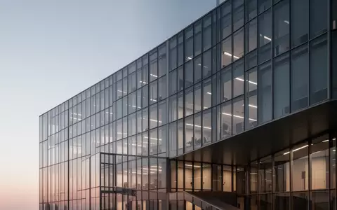 Ein modernes Bürogebäude aus Glas und Stahl in der Abenddämmerung. - Foto: über boerse-global.de