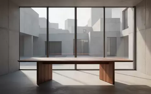 Ein minimalistischer, lichtdurchfluteter Arbeitsbereich mit einem Holztisch in einer modernen, architektonischen Umgebung. - Foto: über boerse-global.de