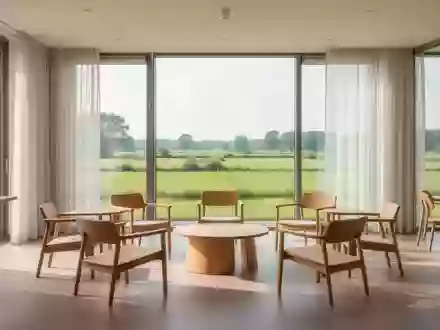 Ein heller, moderner Gemeinschaftsraum mit minimalistischen Holzmöbeln und Blick auf eine grüne Landschaft. - Foto: über boerse-global.de