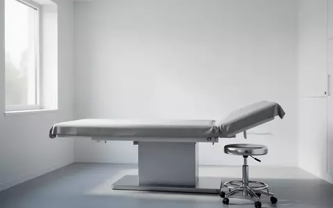 Ein minimalistischer, heller Behandlungsraum in einer medizinischen Einrichtung mit einer leeren Untersuchungsliege. - Foto: über boerse-global.de