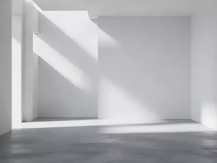 Ein minimalistischer, heller Innenraum mit klaren geometrischen Schattenwürfen auf einer glatten Betonwand. - Foto: über boerse-global.de