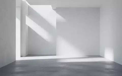 Ein minimalistischer, heller Innenraum mit klaren geometrischen Schattenwürfen auf einer glatten Betonwand. - Foto: über boerse-global.de