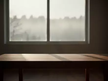 Ein minimalistischer, ruhig gestalteter Raum mit weichem Licht und Blick auf eine neblige Landschaft, der eine nachdenkliche Atmosphäre vermittelt. - Foto: über boerse-global.de