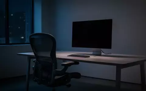 Ein leerer Arbeitsplatz mit einem dunklen Monitor in einem abgedunkelten Büro bei Nacht. - Foto: über boerse-global.de