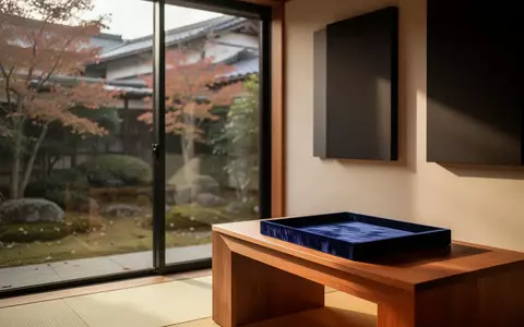 Ein minimalistischer, heller Hörraum mit Holztisch und Blick in einen herbstlichen Garten. - Foto: über boerse-global.de