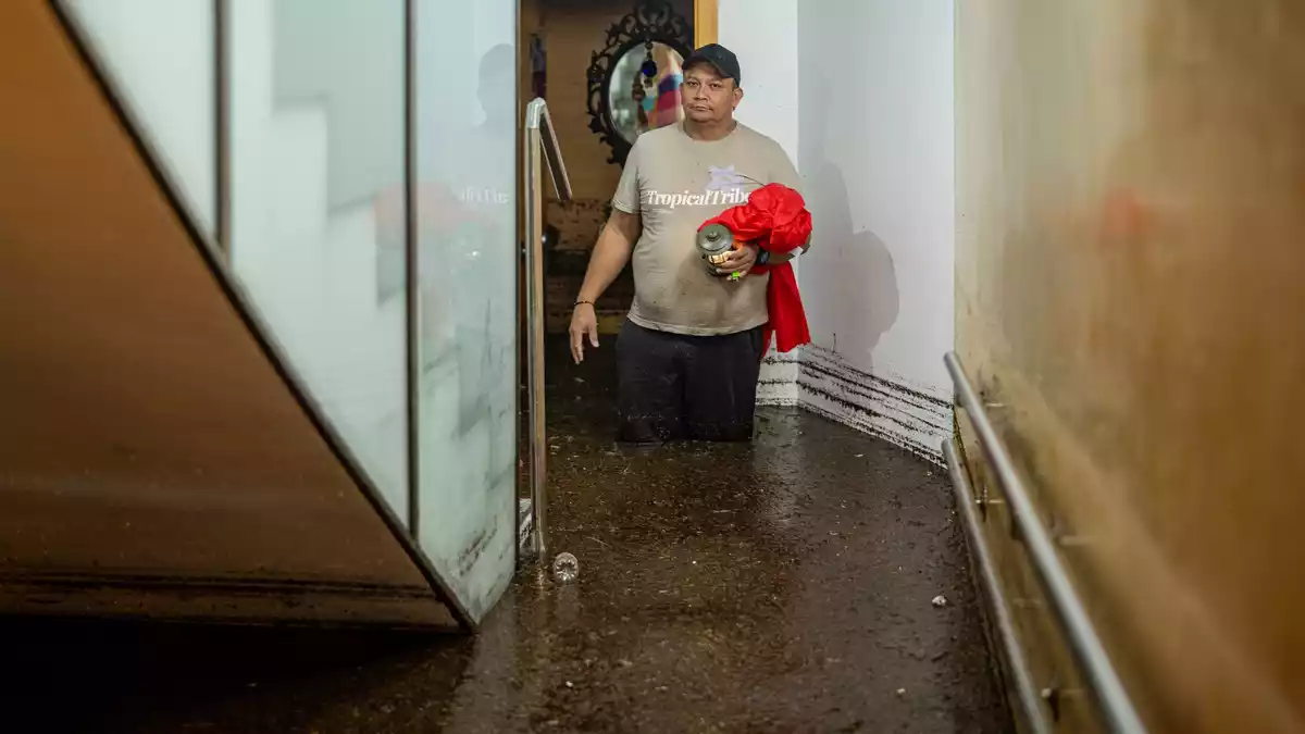 Ein Mann steht im Treppenhaus eines Gebäudes in der an Barcelona grenzenden Stadt L'Hospitalet de Llobregat in mehr als knietiefem Wasser.  - Bild: Lorena Sopêna/EUROPA PRESS/dpa