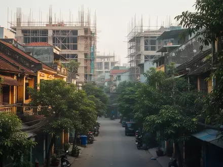 Ein dicht bebautes Stadtviertel in Hanoi mit einer Mischung aus Wohngebäuden und begrünten Straßenbereichen bei Tageslicht. - Foto: über boerse-global.de