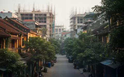 Ein dicht bebautes Stadtviertel in Hanoi mit einer Mischung aus Wohngebäuden und begrünten Straßenbereichen bei Tageslicht. - Foto: über boerse-global.de