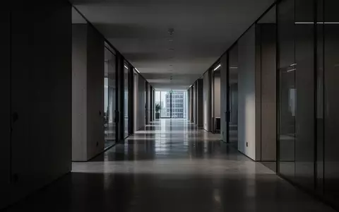 Ein menschenleerer, modern gestalteter Flur in einem Bürogebäude mit klaren Linien und gedimmtem Licht. - Foto: über boerse-global.de