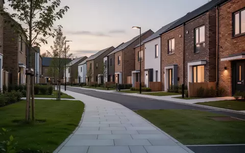 Eine ruhige, moderne Wohnstraße in einer britischen Stadt bei Dämmerung mit Gehwegen und Reihenhäusern. - Foto: über boerse-global.de