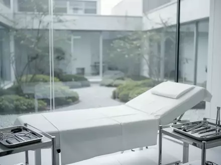 Ein minimalistischer, steriler medizinischer Behandlungsraum mit einer Untersuchungsliege in einem hellen, ruhigen Ambiente. - Foto: ĂŒber boerse-global.de