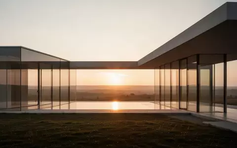 Moderne Architektur eines Gebäudes mit Glasfassade bei Dämmerung in einer weitläufigen Landschaft als Symbol für Standortfragen. - Foto: über boerse-global.de