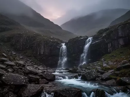 Eine neblige, zerklüftete Berglandschaft im Lake District bei Dämmerung mit einem reißenden Gebirgsbach. - Foto: über boerse-global.de