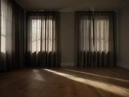 Ein ruhiger, abgedunkelter Raum mit zugezogenen Vorhängen und sanftem Tageslicht, das Schatten auf einen Holzboden wirft. - Foto: über boerse-global.de