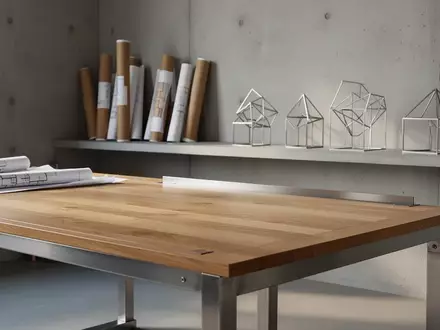 Ein minimalistisches, helles Industriedesign-Studio mit einem leeren Arbeitstisch aus Eichenholz und Stahl in einer ruhigen Umgebung. - Foto: über boerse-global.de