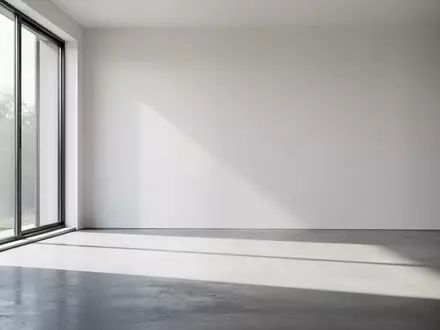 Ein minimalistischer, moderner Raum mit natürlichem Lichteinfall und klaren Schatten auf einem polierten Betonboden. - Foto: über boerse-global.de