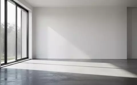 Ein minimalistischer, moderner Raum mit natürlichem Lichteinfall und klaren Schatten auf einem polierten Betonboden. - Foto: über boerse-global.de