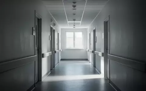 Ein langer, leerer Krankenhausflur mit weißen Wänden und diffusem Tageslicht, der eine ruhige und sterile Atmosphäre vermittelt. - Foto: über boerse-global.de