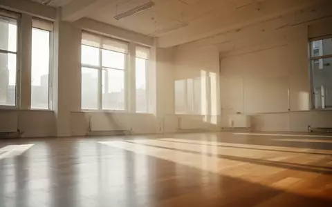Ein heller, minimalistischer Übungsraum mit Holzboden und einfallendem Sonnenlicht in einer ruhigen, leeren Umgebung. - Foto: über boerse-global.de