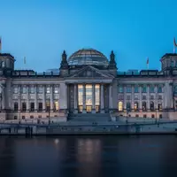 Das Berliner Reichstagsgebäude in der Dämmerung, aufgenommen aus der Ferne über die Spree. - Foto: über boerse-global.de