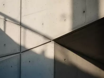 Minimalistische architektonische Texturen mit klaren Linien und Schattenwurf an einer modernen Betonwand. - Foto: über boerse-global.de