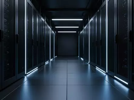 Ein dunkler, industrieller Serverraum mit blauer Beleuchtung und geometrischen Linien auf dem Boden. - Foto: über boerse-global.de