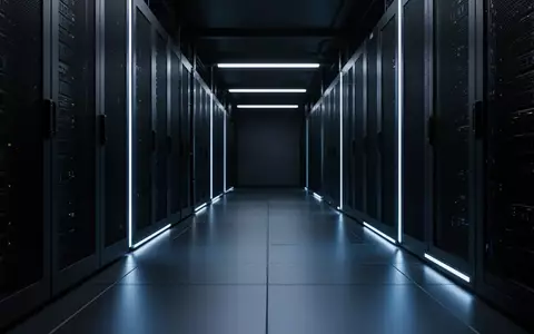 Ein dunkler, industrieller Serverraum mit blauer Beleuchtung und geometrischen Linien auf dem Boden. - Foto: über boerse-global.de