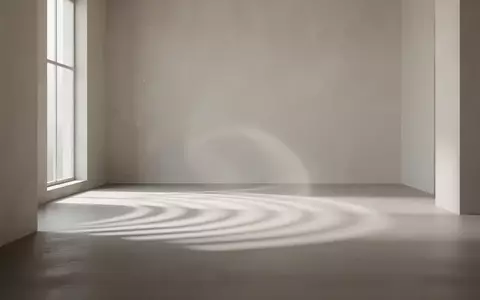 Ein minimalistischer, lichtdurchfluteter Raum mit abstrakten Licht- und Schattenmustern auf einem glatten Boden. - Foto: über boerse-global.de