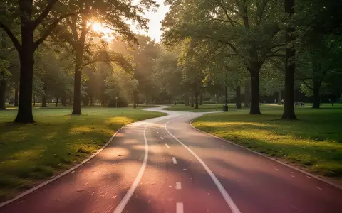 Ein leerer, geschwungener Laufweg in einem sonnendurchfluteten Park während der Abendstunden. - Foto: über boerse-global.de