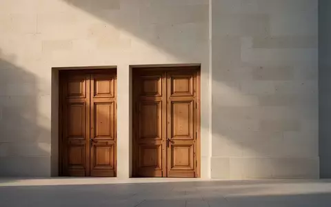 Eine massive, historische Eichentür in einer schlichten Steinwand eines Archivgebäudes. - Foto: über boerse-global.de