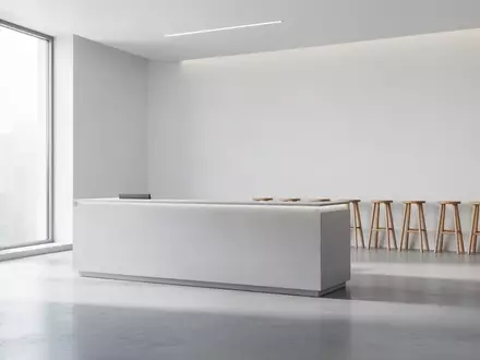 Ein minimalistischer, leerer Kundenservice-Bereich mit hellem Betonboden und dezentem Tageslicht in einem modernen Gebäude. - Foto: über boerse-global.de
