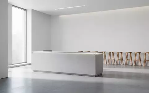 Ein minimalistischer, leerer Kundenservice-Bereich mit hellem Betonboden und dezentem Tageslicht in einem modernen Gebäude. - Foto: über boerse-global.de