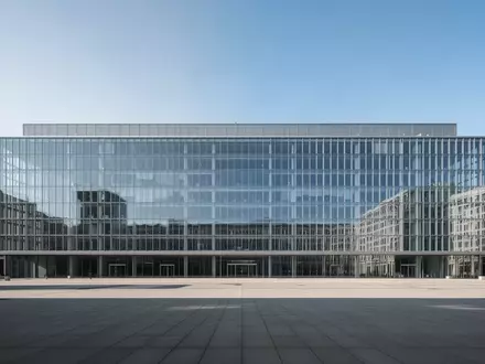 Ein minimalistisches, modernes Verwaltungsgebäude aus Glas und Stahl unter klarem Himmel. - Foto: über boerse-global.de