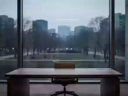 Ein minimalistischer, leerer Büroarbeitsplatz in der Abenddämmerung mit Blick auf einen ruhigen Park. - Foto: über boerse-global.de