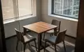 Ein minimalistisch eingerichteter Aufenthaltsraum in einem Büro mit einem Holztisch und Stühlen bei Tageslicht. - Foto: über boerse-global.de