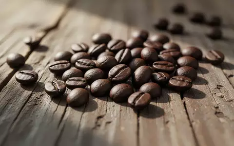 Nahaufnahme von gerösteten Kaffeebohnen auf einer hölzernen Oberfläche bei natürlichem Morgenlicht - Foto: über boerse-global.de