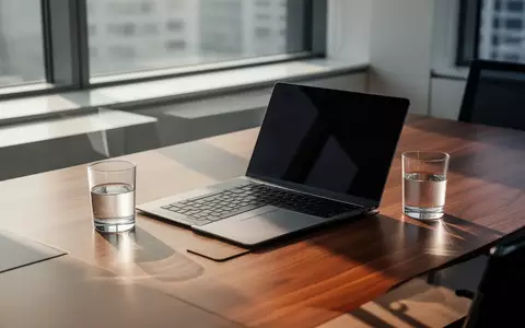 Ein moderner, minimalistischer Büroarbeitsplatz mit Laptop auf einem Holztisch bei natürlichem Tageslicht. - Foto: über boerse-global.de