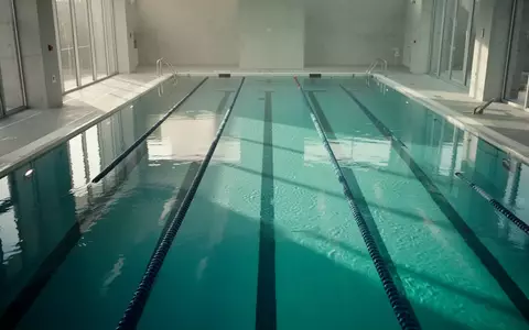 Ein ruhiges Schwimmbecken in einem Hallenbad mit klarem, türkisfarbenem Wasser bei natürlichem Lichteinfall. - Foto: über boerse-global.de