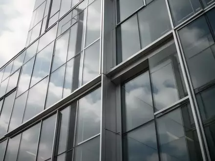 Moderne Glas- und Stahlfassade eines Bürogebäudes mit Reflexionen des Himmels, ohne Personen oder Schriftzüge. - Foto: über boerse-global.de