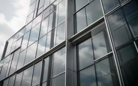 Moderne Glas- und Stahlfassade eines Bürogebäudes mit Reflexionen des Himmels, ohne Personen oder Schriftzüge. - Foto: über boerse-global.de