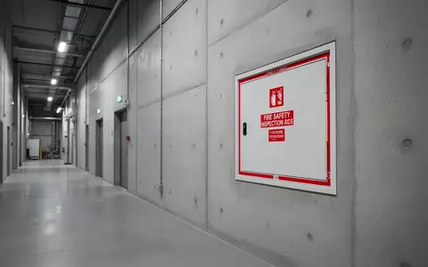 Ein minimalistischer Industrieflur mit einem diskreten Zugang zu sicherheitstechnischen Anlagen an einer Betonwand. - Foto: über boerse-global.de