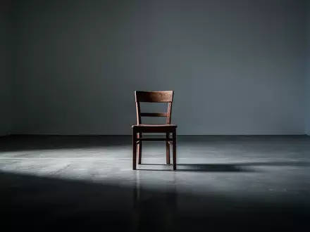 Ein einzelner, leerer Stuhl in einem minimalistischen Raum mit weichen Schatten, der ein Gefühl von Isolation vermittelt. - Foto: über boerse-global.de