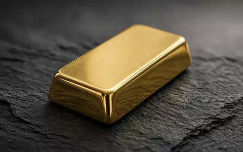Ein einzelner Goldbarren auf einer dunklen Schieferplatte bei natürlichem Licht. - Foto: über boerse-global.de