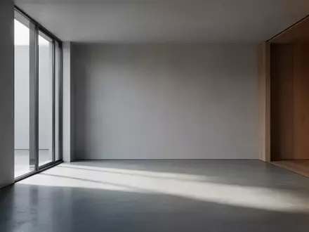Ein minimalistischer, leerer Raum mit poliertem Betonboden und weichem Tageslicht, das durch ein großes Fenster einfällt. - Foto: über boerse-global.de